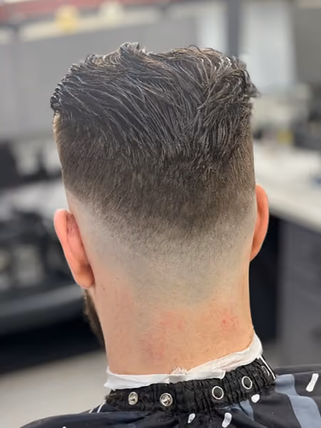 High Drop Skin Fade & Textured Slick Back - Flowing textured sweep on top with an aggressive high drop fade that tapers into a clean V-neckline.