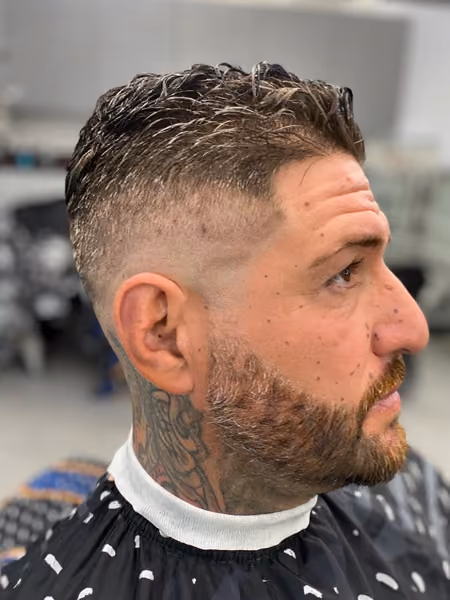 High Bald Fade with Textured Waves & Beard Sculpt - Foil-shaver bald fade transitioning into natural wavy finger-texture on top with crisp beard contour.